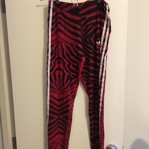Red Adidas track pants in animal print.